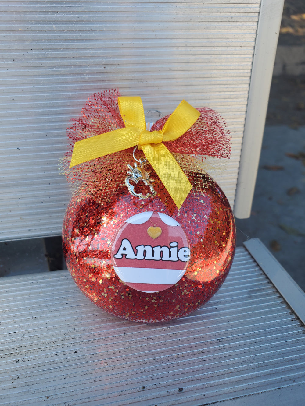 A red pumpkin with a yellow ribbon on it - the ANNIE Christmas Ornament by The Lobby Boutique, a unique Christmas ornament.