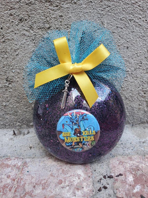 a handmade dark purple and black glitter acrylic christmas ornament for she kills monsters. perfect gift or keepsake for broadway performers from the lobby boutique on etsy. includes a dagger charm and a yellow tulle bow a handmade dark purple and black glitter acrylic christmas ornament for she kills monsters. perfect gift or keepsake for broadway performers from the lobby boutique on etsy. includes a dagger charm and a yellow tulle bow