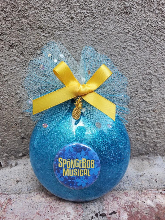 a handmade blue glitter acrylic christmas ornament for spongebob musical keepsake from the lobby boutique on etsy